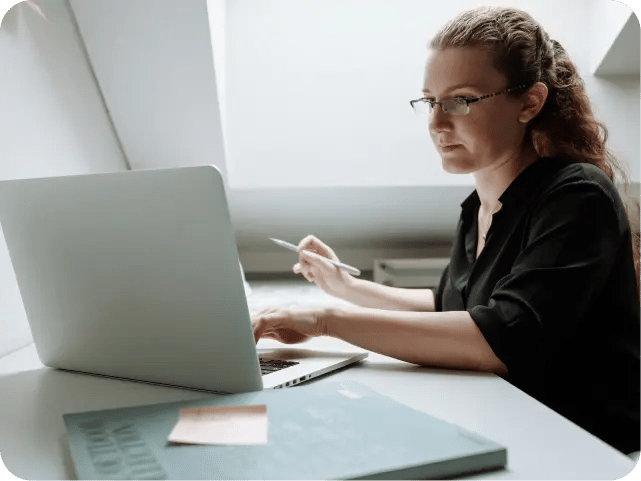 A woman focused on her work while using a laptop.