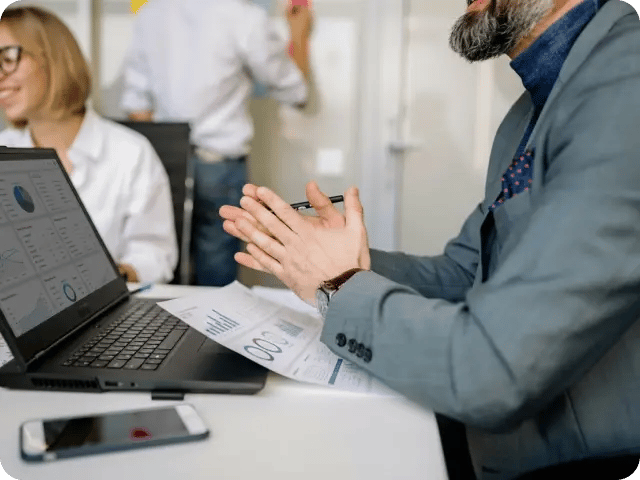 A meeting room where three people are engaged in a professional discussion.