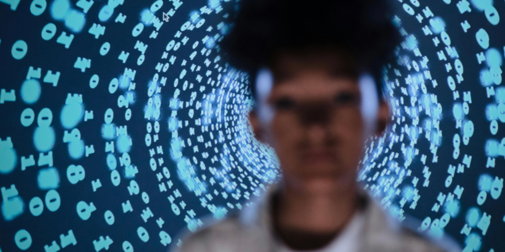 Defocused photo of a young individual encircled by code, symbolizing the risk of AI investments and vendor failures.